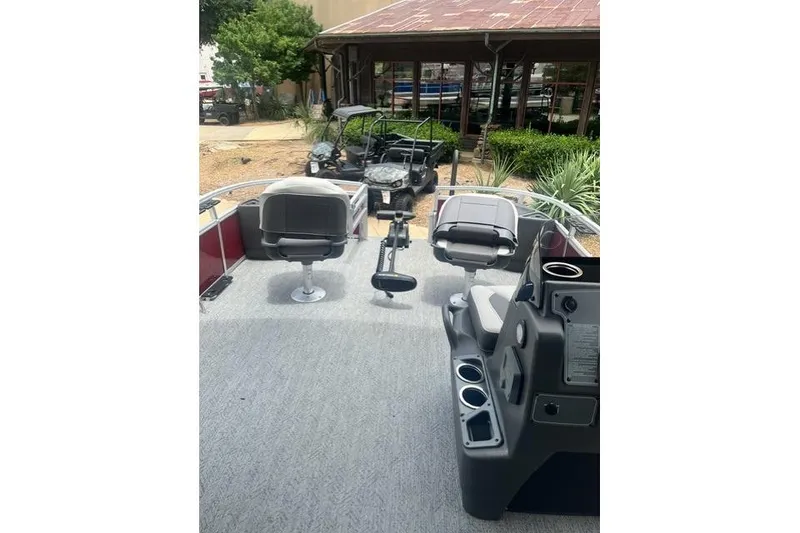 Slide: The Image of 2026 Sun Tracker Bass Buggy 18 DLX pontoon boat interior with seating and control console. - 1
