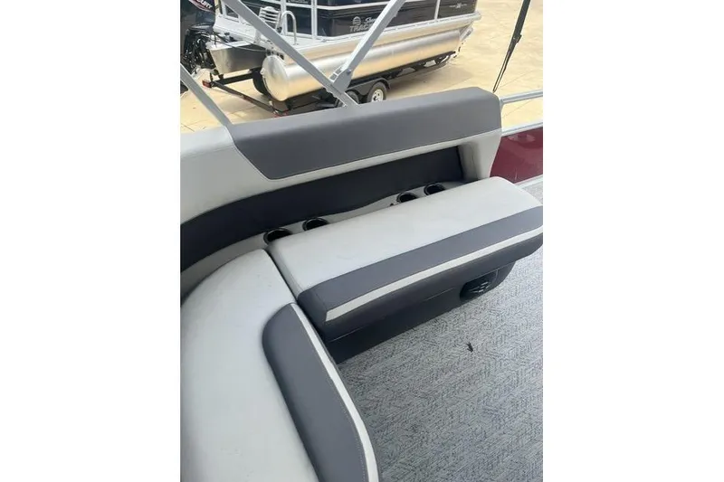 Slide: The Image of 2026 Sun Tracker Bass Buggy 18 DLX interior seating with cup holders and gray upholstery. - 2