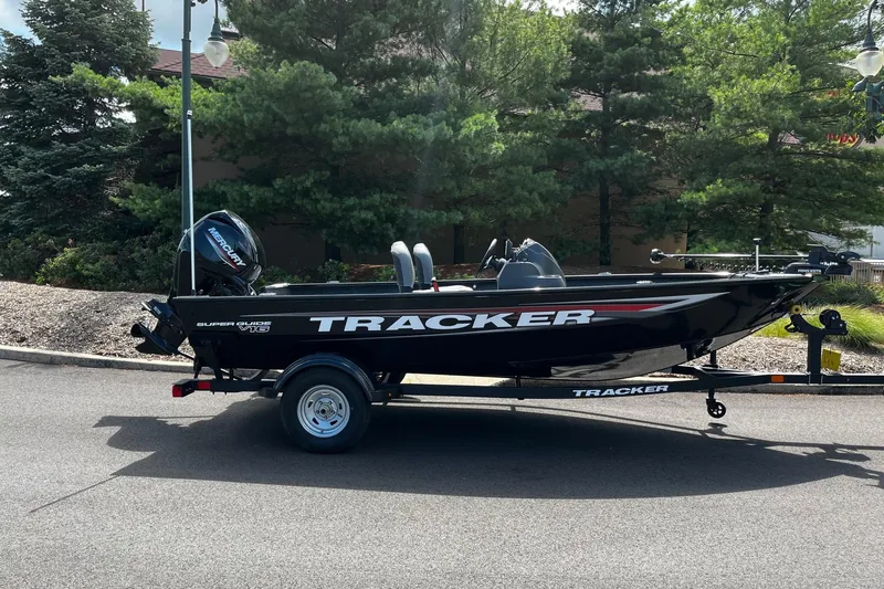 Slide: The Image of 2026 Tracker Super Guide V-16 SC boat on trailer, parked on a road. - 47
