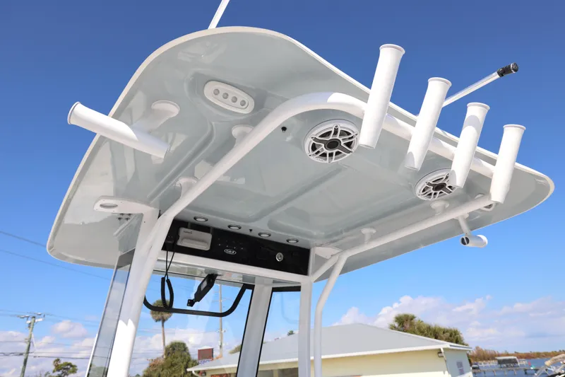 Slide: The Image of 2026 Sea Hunt Gamefish 27 boat top with rod holders and speakers against blue sky. - 10