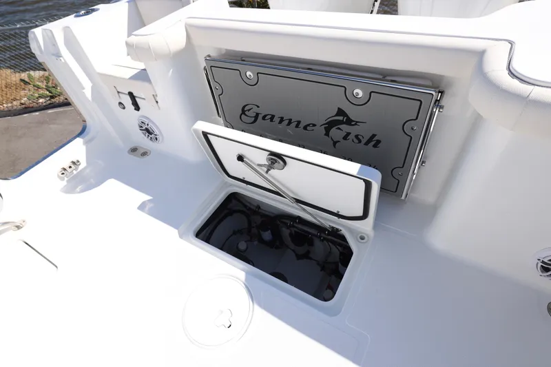 Slide: The Image of 2026 Sea Hunt Gamefish 27 Forward Seating boat interior with storage compartment open. - 18