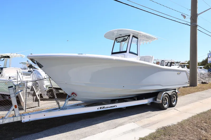 Slide: The Image of 2026 Sea Hunt Gamefish 27 Forward Seating boat on trailer, parked outdoors. - 27