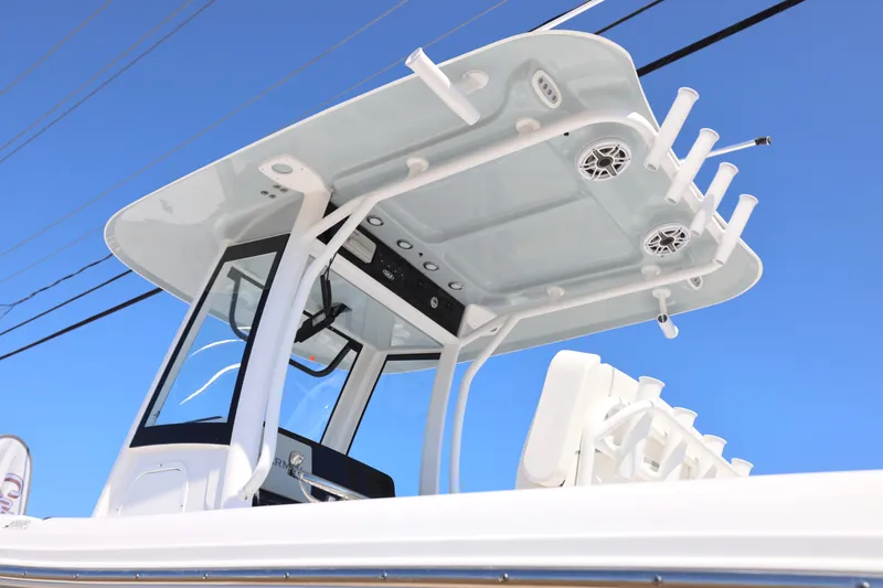 Slide: The Image of 2026 Sea Hunt Gamefish 27 boat with forward seating and T-top against blue sky. - 29