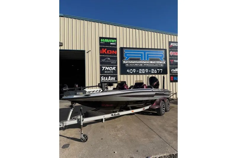 The Image of 2021 Bass Cat Lynx boat on trailer outside marine shop. - 1