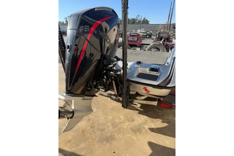 Slide: The Image of 2021 Bass Cat Lynx boat with powerful outboard motor, parked on a trailer. - 5