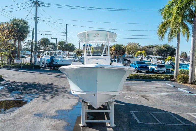 Slide: The Image of 2026 Sea Hunt Ultra 229 boat in parking lot under sunny sky. - 6