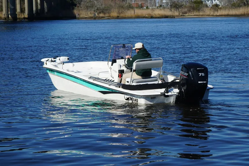 Slide: The Image of 2021 Mako Pro Skiff 17 CC boat on calm water, featuring a Mercury 75 outboard motor. - 4