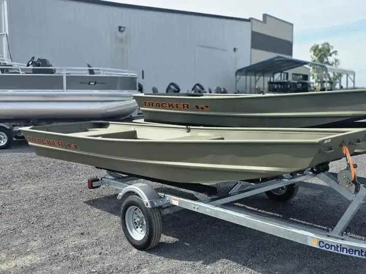 The Image of 2026 Tracker Grizzly 14 Jon boat on trailer outside warehouse. - 1