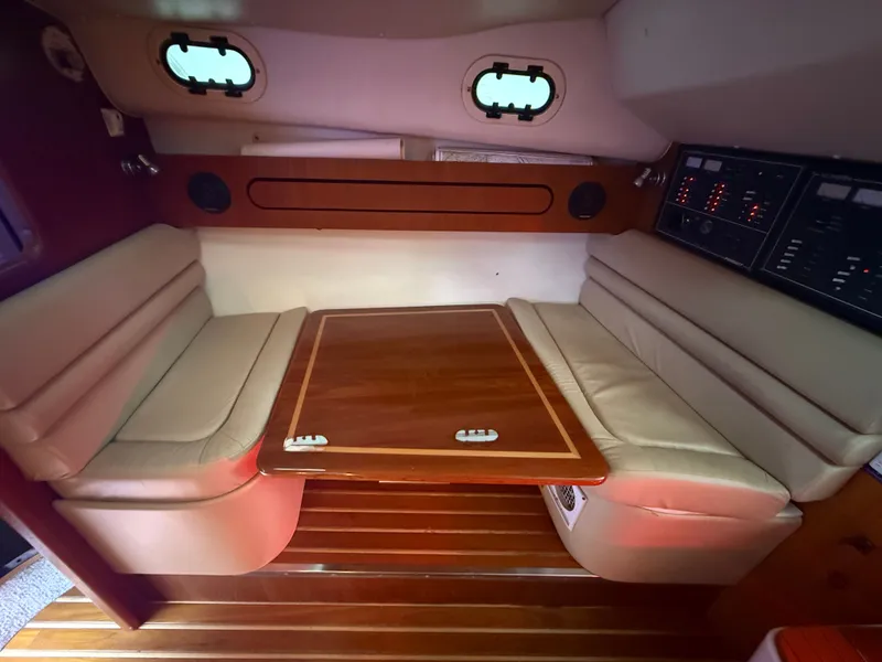 Slide: The Image of Interior of 2003 Pursuit 3400 Express with wooden table and leather seating. - 13