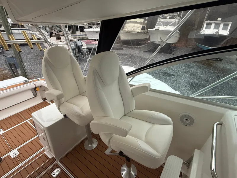 Slide: The Image of Interior of a 2003 Pursuit 3400 Express boat with white seats. - 33