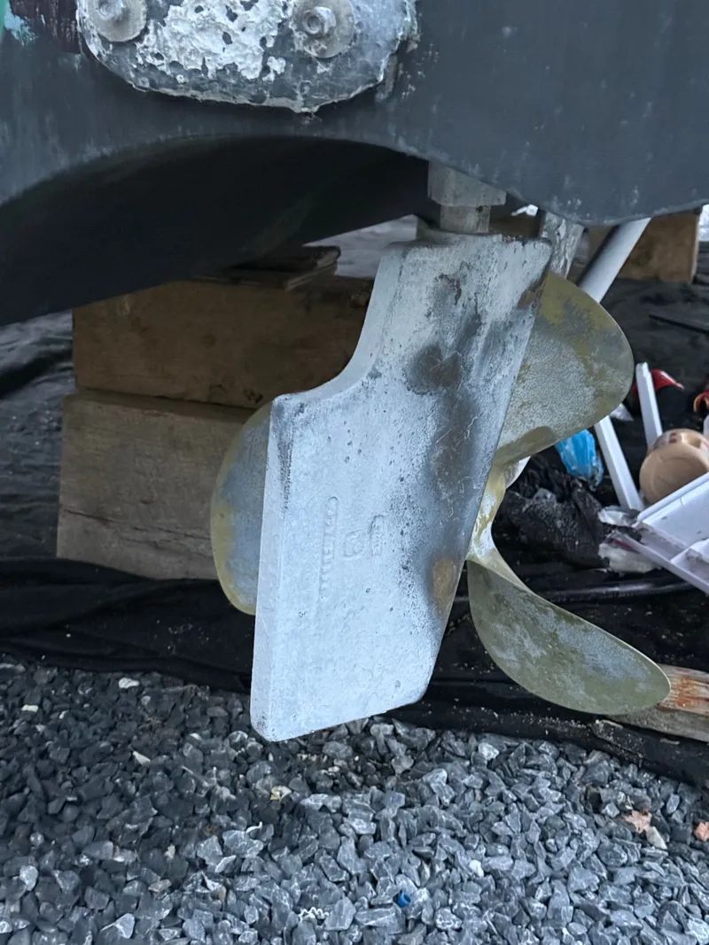 Slide: The Image of 2003 Pursuit 3400 Express boat propeller on gravel surface. - 47