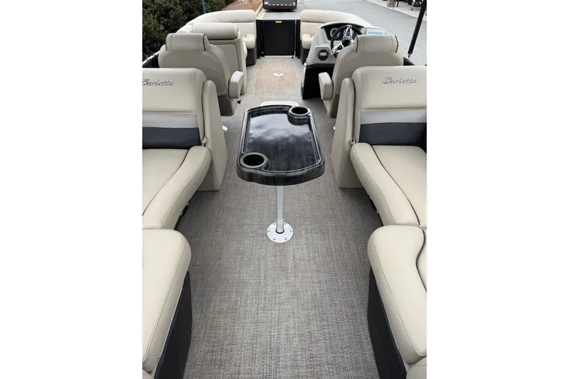 Slide: The Image of 2021 Barletta C22QC pontoon boat interior with beige seating and central table. - 12