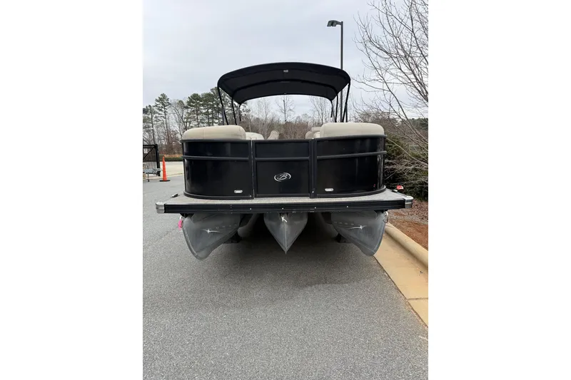 Slide: The Image of 2021 Barletta C22QC pontoon boat with black exterior, parked on pavement. - 20