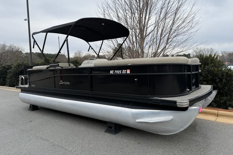 Slide: The Image of 2021 Barletta C22QC pontoon boat with canopy, parked on pavement. - 21