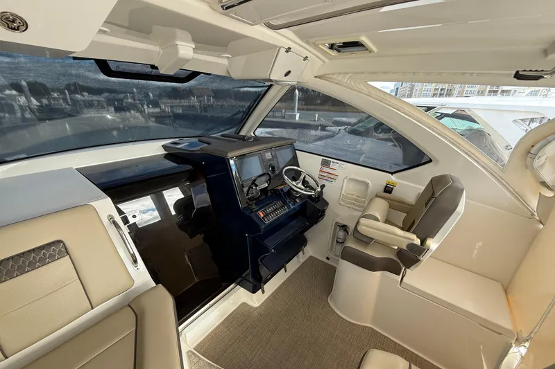 Slide: The Image of 2019 Pursuit OS 355 Offshore boat interior with helm, seating, and navigation equipment. - 13