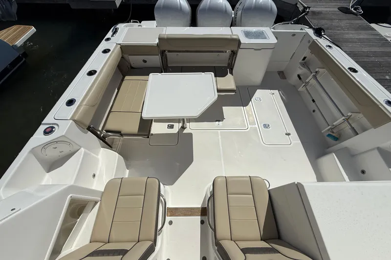 Slide: The Image of 2019 Pursuit OS 355 Offshore boat docked in a marina under clear blue skies. - 2