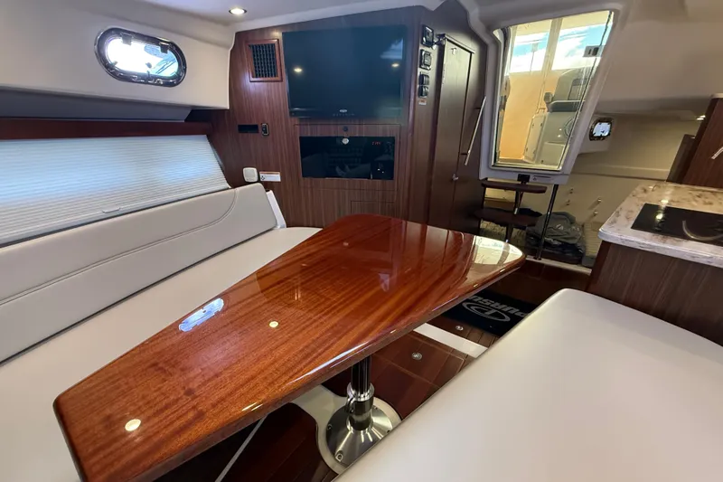 Slide: The Image of Luxurious interior of 2019 Pursuit OS 355 Offshore yacht with elegant seating and wooden table. - 21