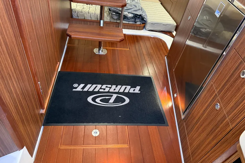 Slide: The Image of 2019 Pursuit OS 355 Offshore cabin interior with sleek wood table and modern amenities. - 24