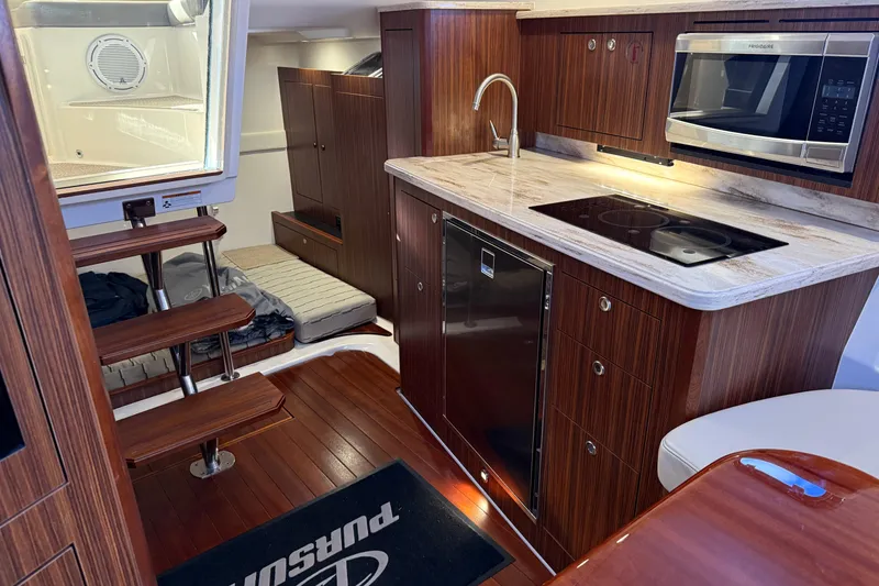 Slide: The Image of Interior of 2019 Pursuit OS 355 Offshore with mounted TV and wood paneling. - 25
