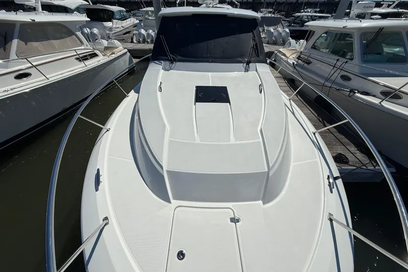 Slide: The Image of 2019 Pursuit OS 355 Offshore boat docked among other vessels. - 38