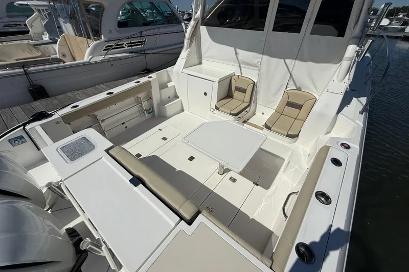 Slide: The Image of 2019 Pursuit OS 355 Offshore boat with triple Yamaha 300 engines docked at marina. - 4