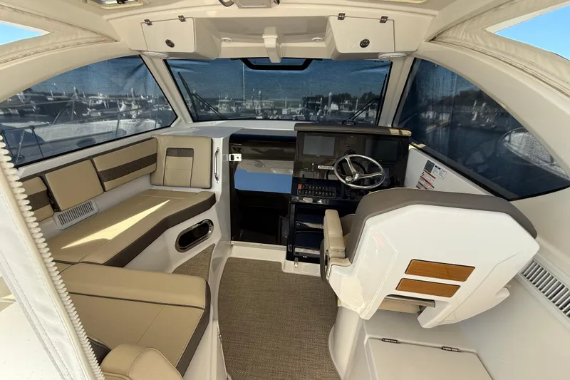 Slide: The Image of 2019 Pursuit OS 355 Offshore boat interior with seating and table, docked at marina. - 7