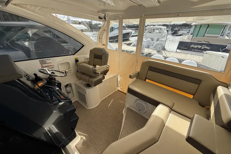 Slide: The Image of 2019 Pursuit OS 355 Offshore boat interior with beige seating and table setup. - 8
