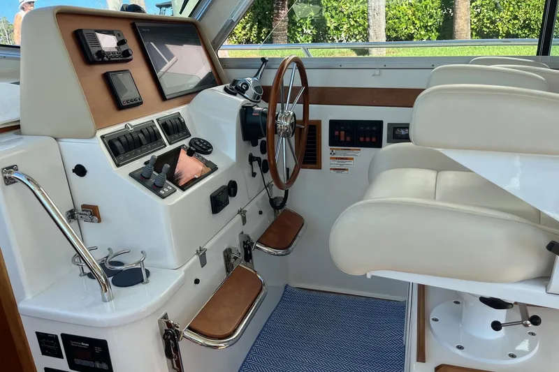 Slide: The Image of 2017 Back Cove 37 helm with modern controls, wooden steering wheel, and comfortable seating. - 13