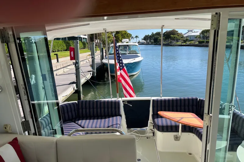 Slide: The Image of Interior view of 2017 Back Cove 37 yacht with American flag and waterfront scenery. - 14