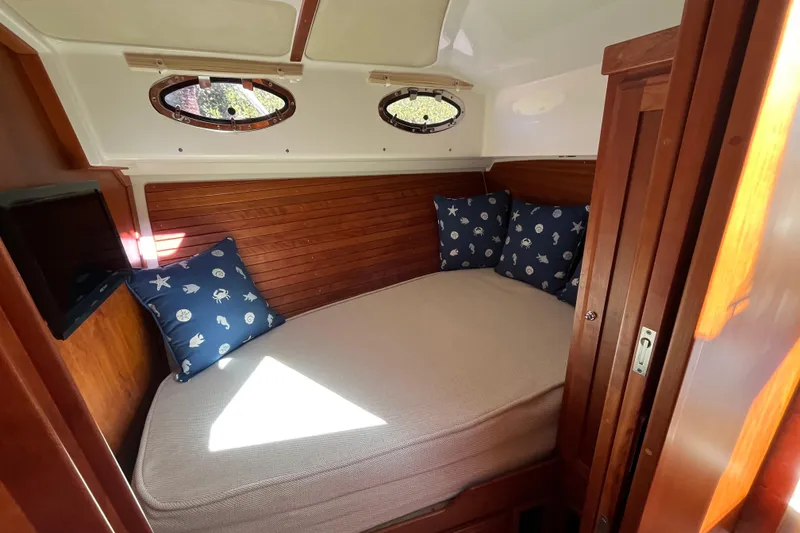 Slide: The Image of Cozy cabin interior of 2017 Back Cove 37 with nautical-themed pillows and wooden accents. - 9