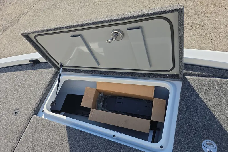 Slide: The Image of Open storage compartment on iKon LX21 boat, revealing a cardboard box inside. - 13