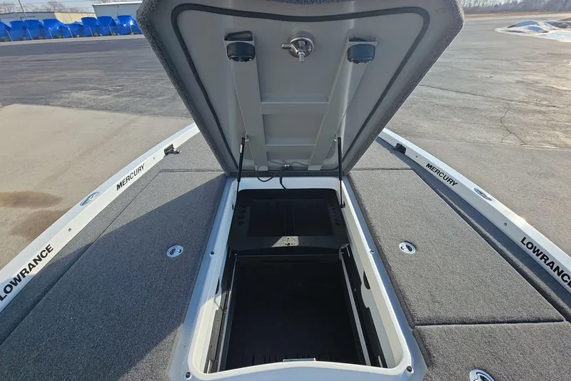Slide: The Image of Open storage compartment on 2025 iKon LX21 boat deck, featuring Lowrance and Mercury branding. - 6