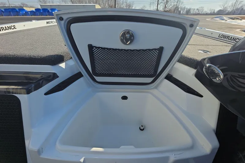 Slide: The Image of 2025 iKon LX21 boat storage compartment with netting and latch, featuring Lowrance branding. - 9