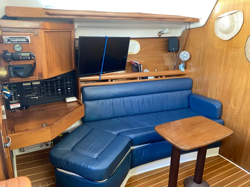 Slide: The Image of Interior of a 2003 Catalina 350 yacht with blue leather couch. - 13