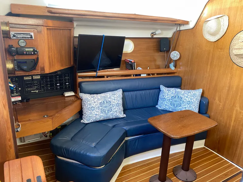Slide: The Image of Interior of a 2003 Catalina 350 yacht with blue leather couch. - 21