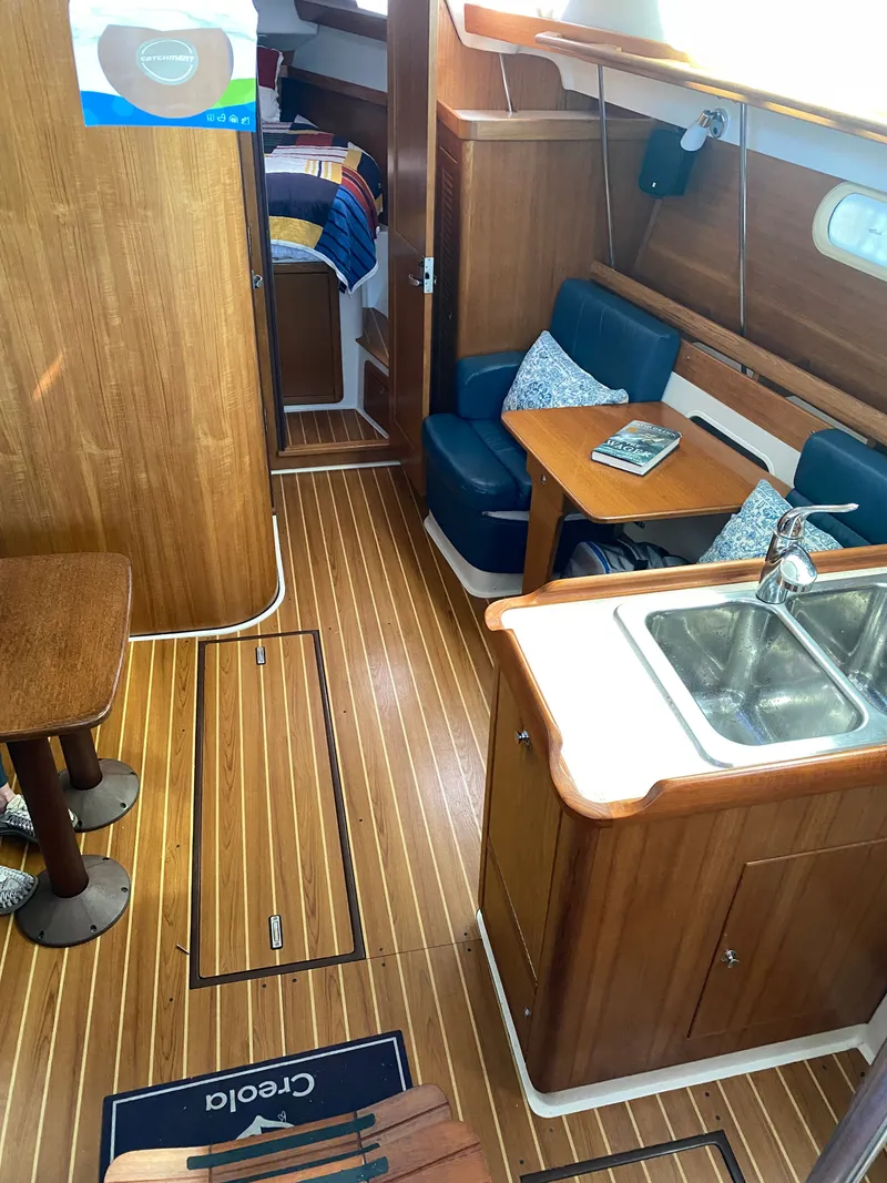Slide: The Image of Interior of a 2003 Catalina 350 yacht with wooden flooring and seating area. - 30
