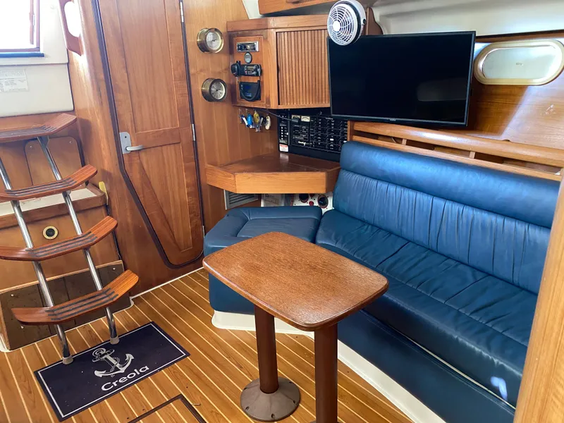Slide: The Image of Interior of a 2003 Catalina 350 yacht with blue seating and wooden table. - 32