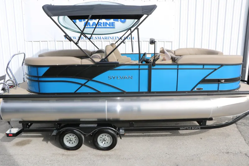 Slide: The Image of 2026 Sylvan Mirage 822 LZ pontoon boat with blue and black design on trailer. - 10