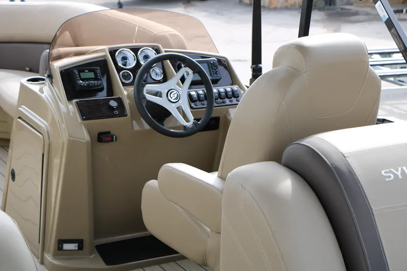 Slide: The Image of 2026 Sylvan Mirage 822 LZ boat interior with steering console and beige seating. - 20