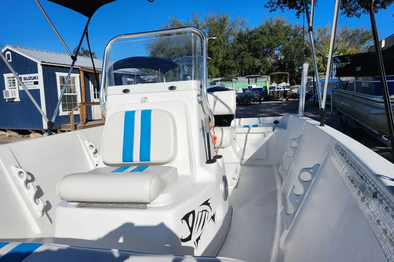 Slide: The Image of 2018 Glasstream 17 CCR boat with blue-striped seating, parked outdoors near marine shop. - 21