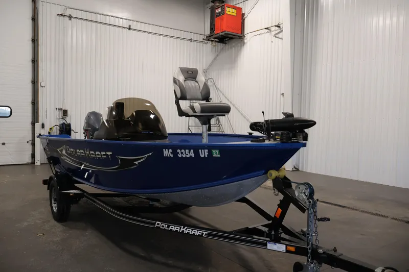 Slide: The Image of 2017 Polar Kraft Outlander 156 SC boat in a garage, blue exterior, on a trailer. - 3