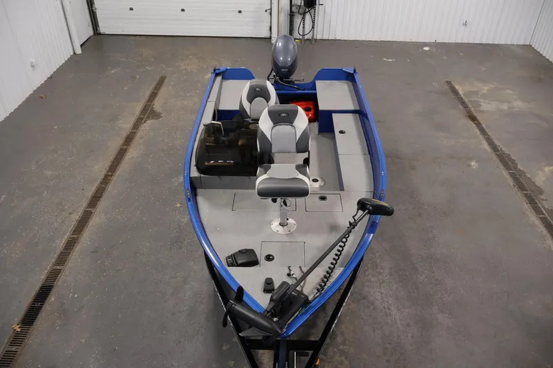 Slide: The Image of 2017 Polar Kraft Outlander 156 SC boat in a garage, featuring seating and motor. - 9