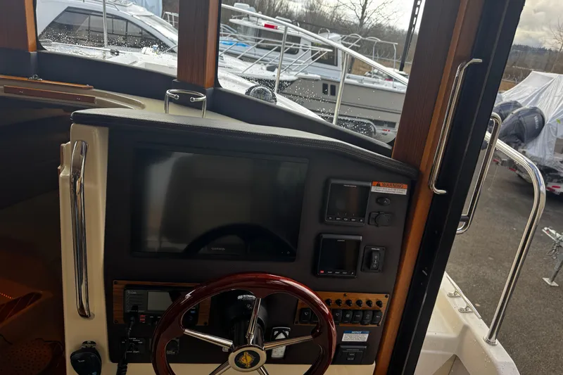 Slide: The Image of 2023 Ranger Tug R-31 CB helm with navigation controls and steering wheel. - 16
