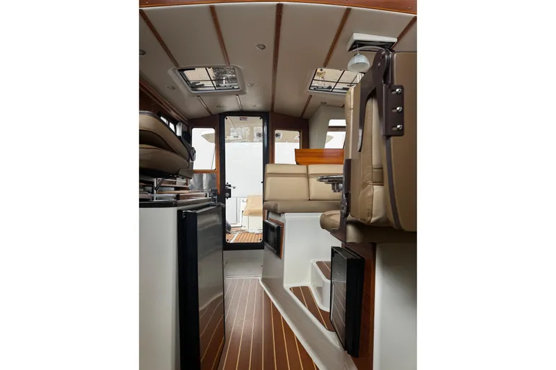 Slide: The Image of Interior of 2023 Ranger Tug R-31 CB, featuring modern seating and wood accents. - 18