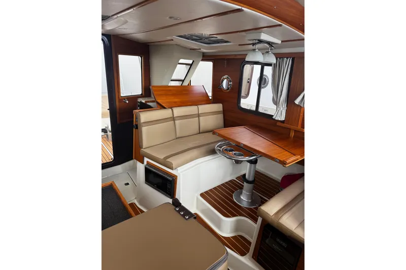 Slide: The Image of Interior of 2023 Ranger Tug R-31 CB, featuring elegant wood finishes and comfortable seating. - 19