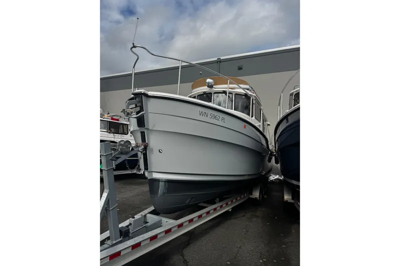 Slide: The Image of 2023 Ranger Tug R-31 CB boat on trailer, parked outdoors. - 2