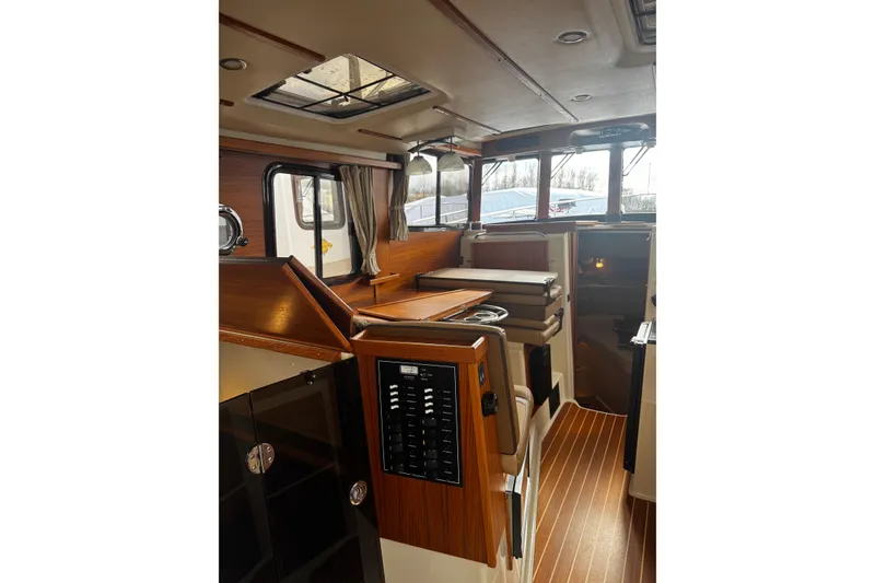 Slide: The Image of 2023 Ranger Tug R-31 CB interior with wood accents and modern amenities. - 21