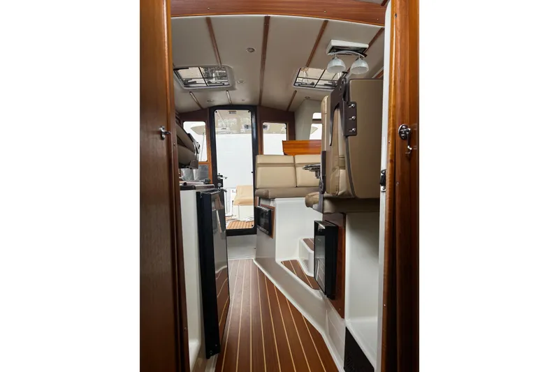 Slide: The Image of 2023 Ranger Tug R-31 CB interior with wood accents and modern seating. - 3