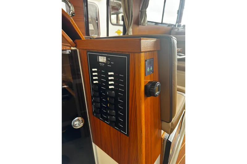 Slide: The Image of Control panel of 2023 Ranger Tug R-31 CB with wooden finish and switches. - 4