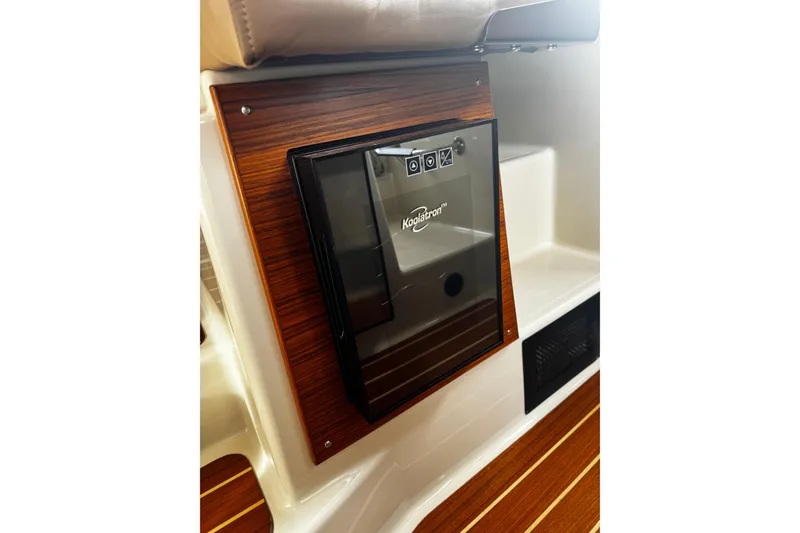 Slide: The Image of 2023 Ranger Tug R-31 CB interior with Koolatron fridge, wood paneling, and seating. - 5